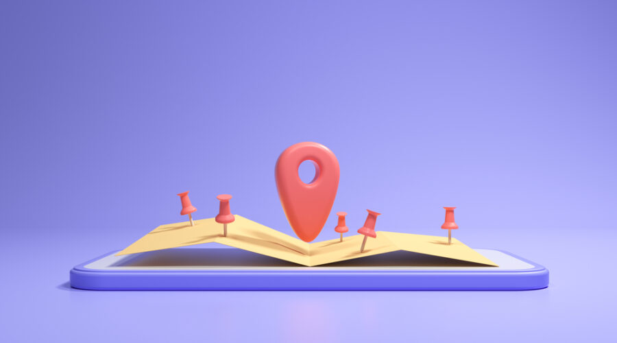 An open book sitting on a purple background. Small red GPS location markers litter the pages with a larger one in the center.